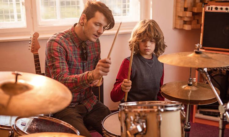 man teaching young boy drums
